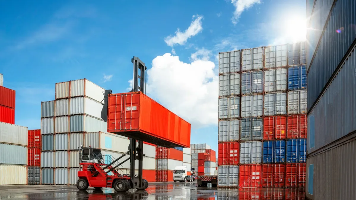 Xe nâng bốc container tại bãi cảng — minh họa phân nhóm điều kiện Incoterms 2020 (E, F, C, D) và trách nhiệm cước, bảo hiểm, rủi ro